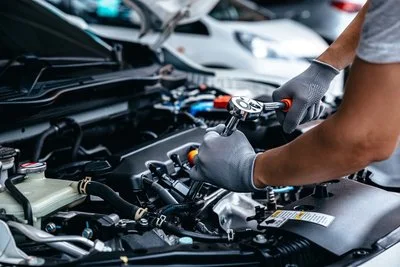 Autotechnicus werkt onder de motorkap